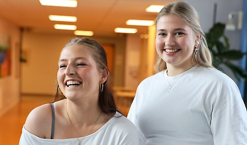 Två kvinnliga elever i korridoren